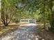 A front shot of a small home surrounded by mature trees in a beautiful neighborhood at 7813 Cadillac Ave, Hudson, FL 34667