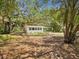 View of home surrounded by large mature trees with a lovely landscaped yard at 7813 Cadillac Ave, Hudson, FL 34667
