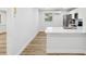 This bright kitchen offers quartz counters, white cabinets, stainless appliances, and wood-look floors at 7813 Cadillac Ave, Hudson, FL 34667