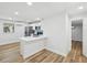Open-concept kitchen with white cabinetry, stainless appliances, quartz counters, and wood-look floors at 7813 Cadillac Ave, Hudson, FL 34667