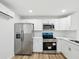 Bright kitchen with stainless steel appliances, white cabinets, and subway tile backsplash at 7813 Cadillac Ave, Hudson, FL 34667