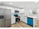 This bright kitchen features stainless appliances, white cabinetry, quartz counters, and wood-look floors at 7813 Cadillac Ave, Hudson, FL 34667