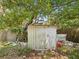 A storage shed in a wooded area with leaves and debris on the ground at 7813 Cadillac Ave, Hudson, FL 34667