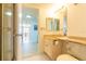 Bathroom including the vanity, toilet, shower, and view to hallway and beyond at 80 Rogers St # 6D, Clearwater, FL 33756