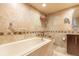 Bright bathroom showcasing a soaking tub, neutral tile, and a vanity at 80 Rogers St # 6D, Clearwater, FL 33756