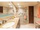 Bathroom featuring double sinks, a glass shower, and plenty of storage at 80 Rogers St # 6D, Clearwater, FL 33756