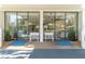 Building entryway with double glass doors, benches and planters creating a welcoming atmosphere at 80 Rogers St # 6D, Clearwater, FL 33756