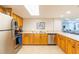 Well-lit kitchen features stainless steel appliances, wooden cabinets, and a tile floor at 80 Rogers St # 6D, Clearwater, FL 33756