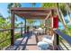 Outdoor dining area under a wooden pergola with a grill, perfect for entertaining with ocean views at 80 Rogers St # 6D, Clearwater, FL 33756