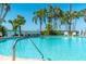 Inviting outdoor pool with palm trees and a stunning ocean view on a clear, sunny day at 80 Rogers St # 6D, Clearwater, FL 33756
