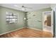 Bedroom with wood floor, ample natural light from a window, and floating shelves at 8246 Westfield Dr, Port Richey, FL 34668