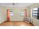 Bright bedroom featuring hardwood floors, two large windows, and a ceiling fan at 8246 Westfield Dr, Port Richey, FL 34668