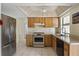 Efficient kitchen featuring stainless steel appliances, light wood cabinets, and white tile flooring at 8246 Westfield Dr, Port Richey, FL 34668