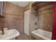 Bathroom featuring a soaking tub, tiled walls, and decorative fixtures at 8737 Beaver Ln, Port Richey, FL 34668