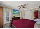 Bedroom with dark wood furniture, ceiling fan, television, and walk out to patio at 8737 Beaver Ln, Port Richey, FL 34668