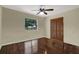 Bedroom with wood floors, closet, ceiling fan, and natural light from a window at 8737 Beaver Ln, Port Richey, FL 34668