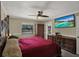 Bedroom with dark wood furniture, ceiling fan, television, and natural light from window at 8737 Beaver Ln, Port Richey, FL 34668