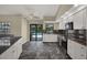 Bright kitchen with stainless appliances, granite countertops, and a view to the pool at 8737 Beaver Ln, Port Richey, FL 34668