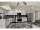 Well-lit kitchen featuring stainless appliances, granite countertops, and stylish flooring at 8737 Beaver Ln, Port Richey, FL 34668