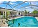 Enclosed in-ground pool with seating area, ideal for relaxation and recreation at 8737 Beaver Ln, Port Richey, FL 34668