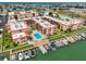 Stunning aerial view of waterfront condos, featuring a pool, boat docks, and lush greenery in a coastal setting at 8931 Blind Pass Rd # 262, St Pete Beach, FL 33706