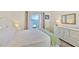 Bright main bedroom features water view, dresser, side tables and coastal decor at 8931 Blind Pass Rd # 262, St Pete Beach, FL 33706
