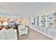 Comfortable living room featuring a mirrored wall, built-in shelving, and views of the kitchen at 8931 Blind Pass Rd # 262, St Pete Beach, FL 33706
