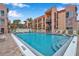 Inviting community pool with lounge chairs surrounded by multi-story residential buildings and lush tropical landscaping at 8931 Blind Pass Rd # 262, St Pete Beach, FL 33706