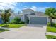 Single-story home featuring a well-maintained lawn, mature landscaping, and an attached two-car garage at 9059 Spruce Creek Cir, Riverview, FL 33578