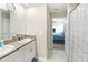 Bathroom showcasing double sinks with granite countertop, cabinets, and adjacent bedroom at 9313 Lemon Drop Loop, Ruskin, FL 33573