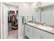 Bathroom showcasing double sinks with granite countertop, cabinets, and walk-in closet at 9313 Lemon Drop Loop, Ruskin, FL 33573