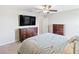 Relaxing main bedroom with ceiling fan and an additional dark wood dresser for ample storage at 9313 Lemon Drop Loop, Sun City Center, FL 33573