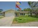 Charming single-story home featuring a well-manicured lawn, stone accents, and attached garage at 9930 121 N St, Seminole, FL 33772
