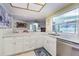 Well-lit kitchen featuring white cabinetry, stainless steel appliances, and ample countertop space at 9930 121 N St, Seminole, FL 33772