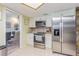 Well-lit kitchen featuring white cabinets, stainless steel appliances, and a tile backsplash at 9930 121 N St, Seminole, FL 33772