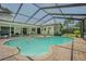 Inviting screened pool with a brick patio and lush landscaping, perfect for outdoor relaxation and entertainment at 9930 121 N St, Seminole, FL 33772