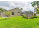 Lush green lawn with palm trees and a screened enclosure of pool area offers plenty of space for outdoor enjoyment at 10002 Colonnade Dr, Tampa, FL 33647