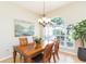 Cozy dining room featuring a wooden table set beneath a chandelier and a large window offering natural light at 10002 Colonnade Dr, Tampa, FL 33647