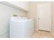 Laundry room with a new washer and dryer set, white cabinets, and tiled floors at 10002 Colonnade Dr, Tampa, FL 33647