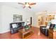 Comfortable living room with hardwood floors, leather seating, and views into the kitchen at 10002 Colonnade Dr, Tampa, FL 33647