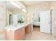 Well-lit main bathroom featuring dual sinks and an open doorway to the bedroom at 10002 Colonnade Dr, Tampa, FL 33647
