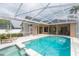 A covered pool with spa, lounge chairs, and sliding glass doors create a perfect outdoor relaxation spot at 10002 Colonnade Dr, Tampa, FL 33647