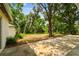 View of a large backyard area with a patio, surrounded by lush trees at 103 Hickory Creek Blvd, Brandon, FL 33511