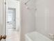 Bright bathroom featuring a shower-tub combination, tiled walls, and neutral flooring at 103 Hickory Creek Blvd, Brandon, FL 33511