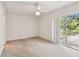Bedroom featuring neutral carpet, sliding glass door, and a ceiling fan with light at 103 Hickory Creek Blvd, Brandon, FL 33511