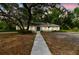 Charming single-story home with mature landscaping, featuring a painted brick facade and inviting walkway to the front door at 103 Hickory Creek Blvd, Brandon, FL 33511