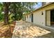 Side exterior view of the house featuring a concrete patio, trees, and neutral-colored siding at 103 Hickory Creek Blvd, Brandon, FL 33511