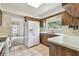 A kitchen featuring wood cabinets, tile floor, white appliances, and a window at 103 Hickory Creek Blvd, Brandon, FL 33511