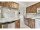 A kitchen featuring wood cabinets, a stainless steel dishwasher, and an eat in counter at 103 Hickory Creek Blvd, Brandon, FL 33511