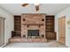 Bright living room featuring a red brick fireplace, dark wood bookshelves, and neutral carpeting at 103 Hickory Creek Blvd, Brandon, FL 33511